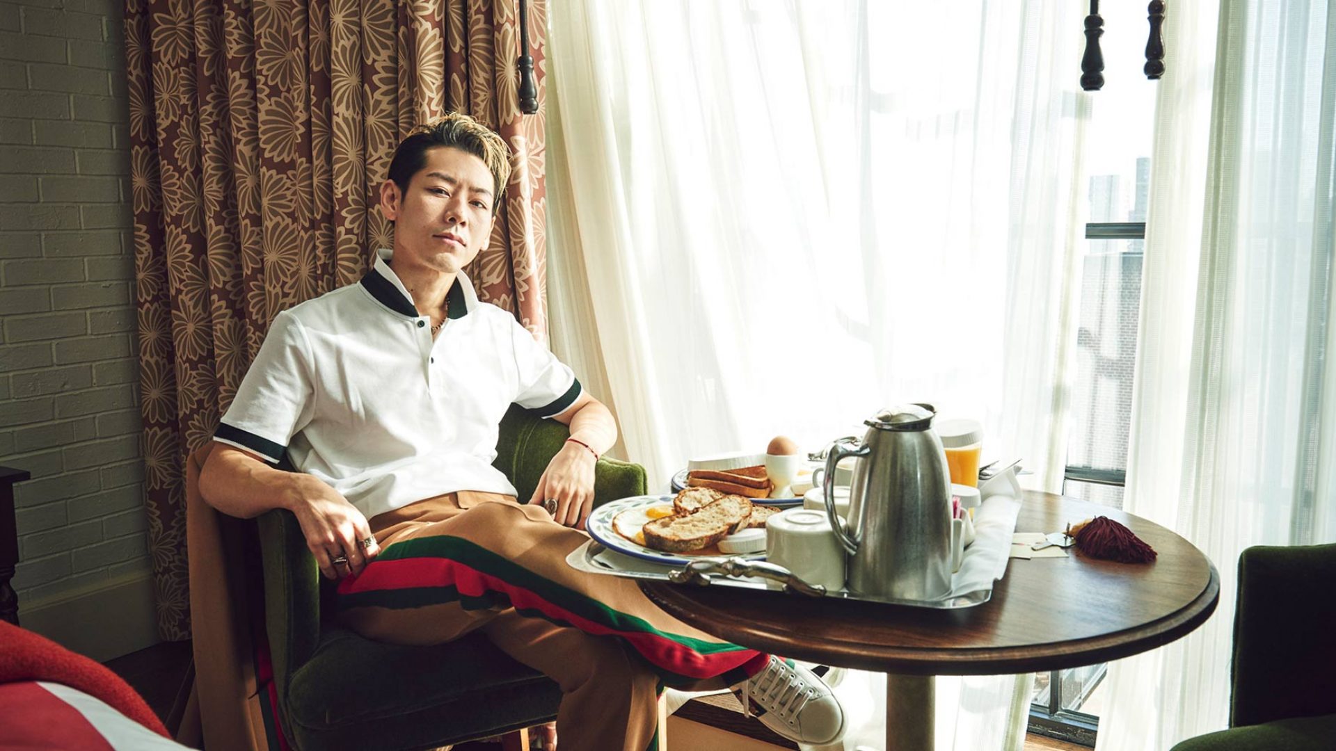 Takeru Kobiyashi sits in a hotel room with room service