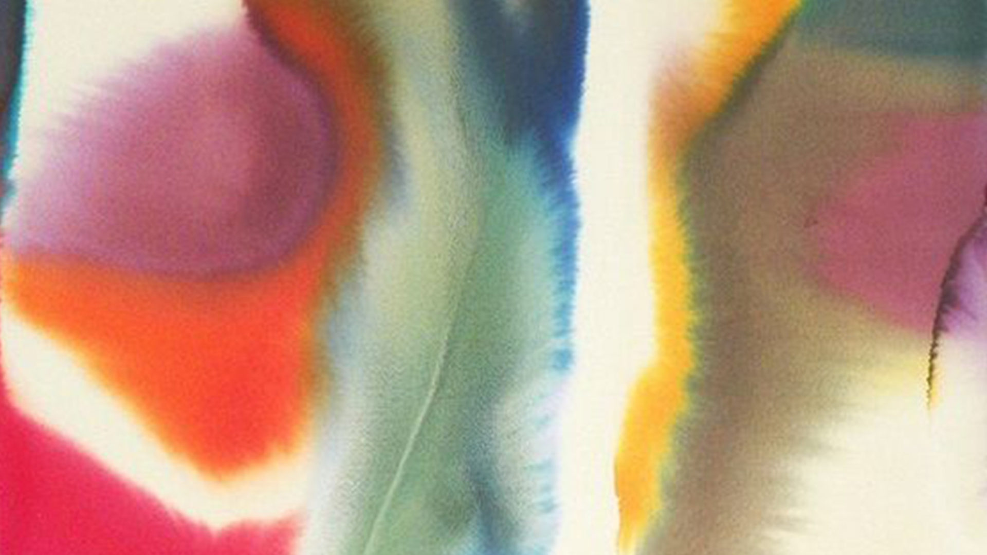 ink drops of multicolours spread across a cream background