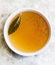 simple cup of broth sitting on a grey marble background