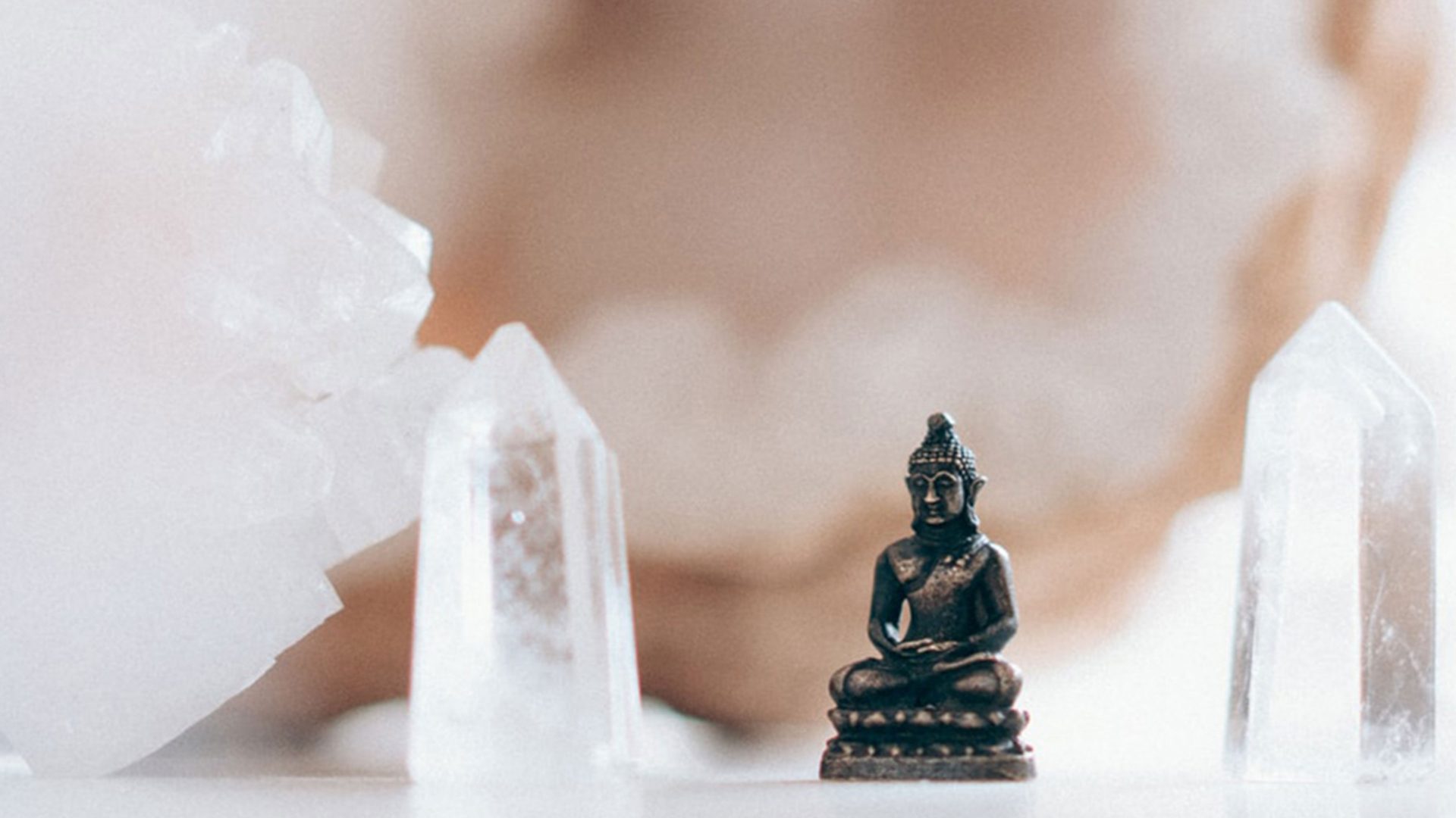 Small buddha figurine framed by crystals