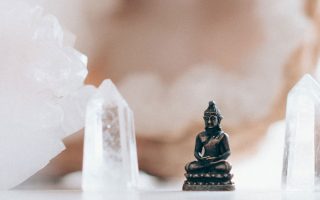 Small buddha figurine framed by crystals