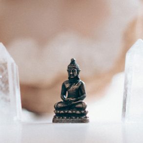 Small buddha figurine framed by crystals
