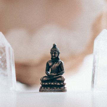 Small buddha figurine framed by crystals