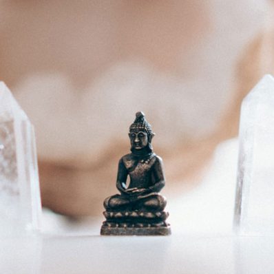 Small buddha figurine framed by crystals