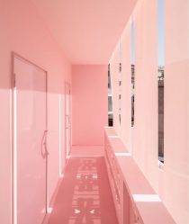 A pastel pink corridor with streaks of daylight coming through