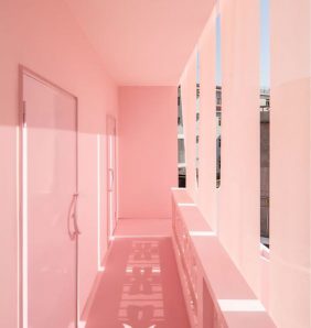 A pastel pink corridor with streaks of daylight coming through