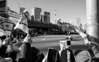 black and white image of flags waving as a long distance runner