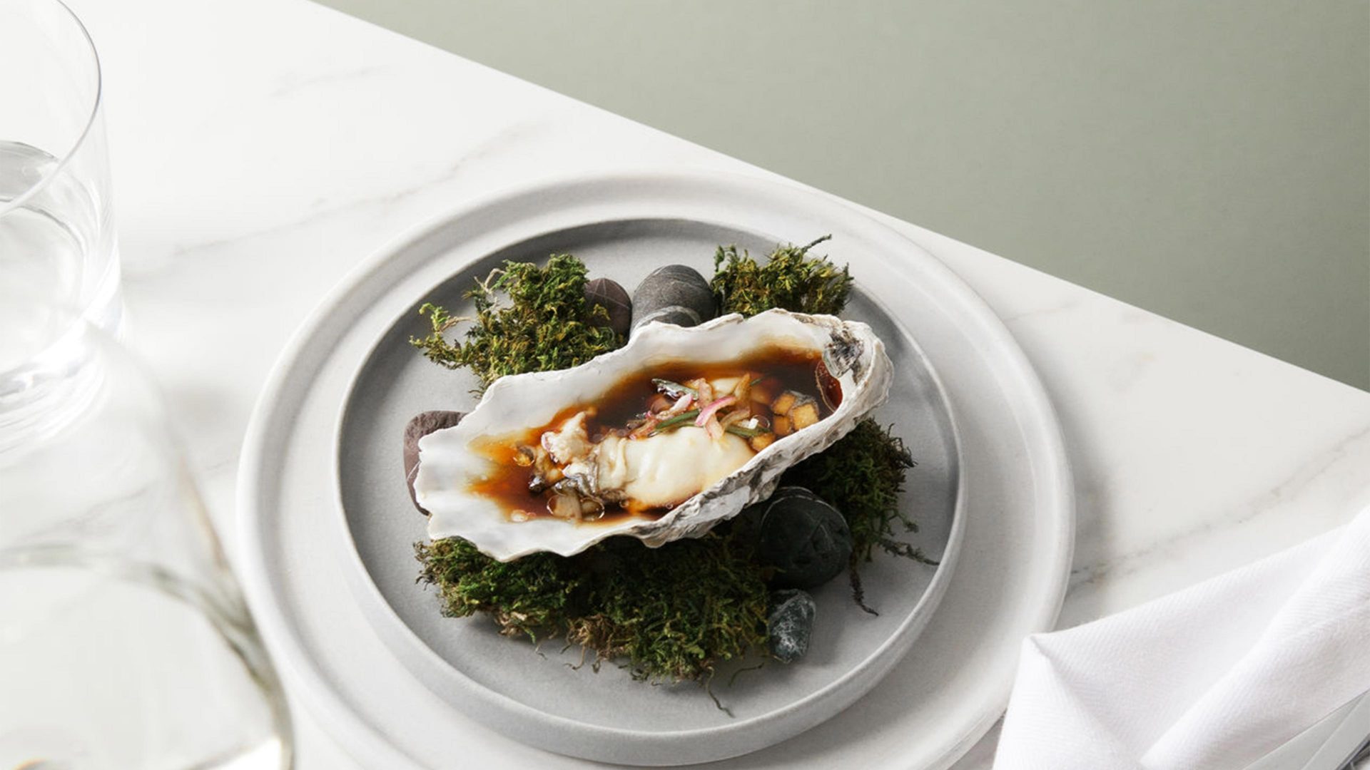 an oyster sitting on a plate on top of grass