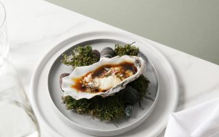 an oyster sitting on a plate on top of grass