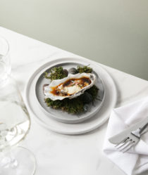 an oyster sitting on a plate on top of grass