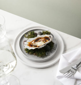 an oyster sitting on a plate on top of grass