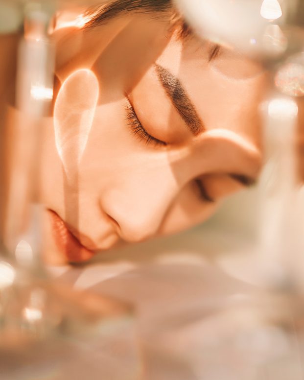mans face leaning into a stream of water
