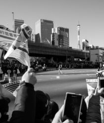black and white image of flags waving as a long distance runner