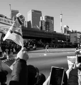black and white image of flags waving as a long distance runner