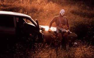 Mexican luchador Dr Wagner Jr poses by his car in front of a sunset