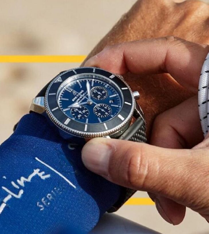 blue mans watch on a wrist coming out of a blue wetsuit