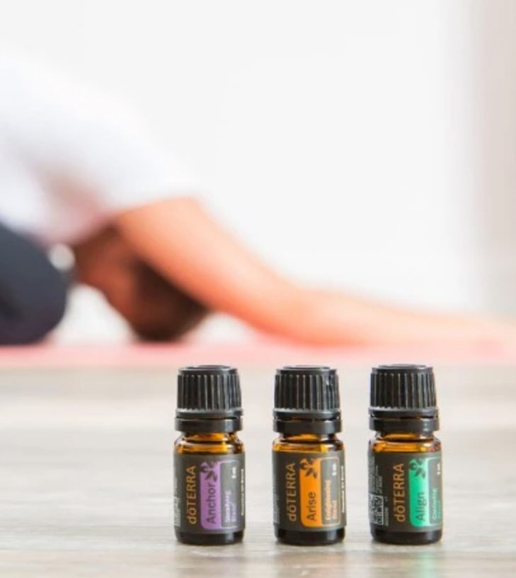 yoga essential oils infront of a woman doing a yoga pose