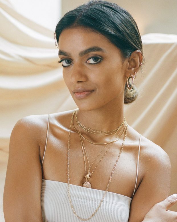 Stella Simona wearing white top and jewellery