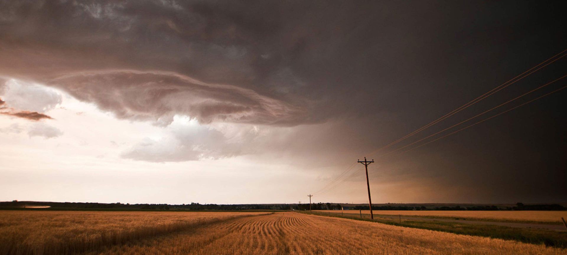 a storm brews over a american corn field