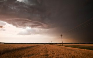 a storm brews over a american corn field