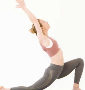 Model wears sports bra and green leggings in yoga pose