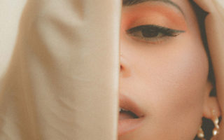 A young woman's face partially obscured by a veil