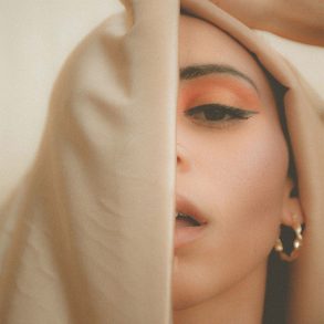 A young woman's face partially obscured by a veil