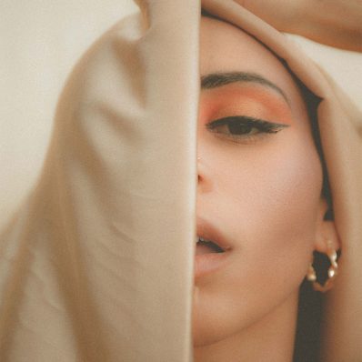 A young woman's face partially obscured by a veil