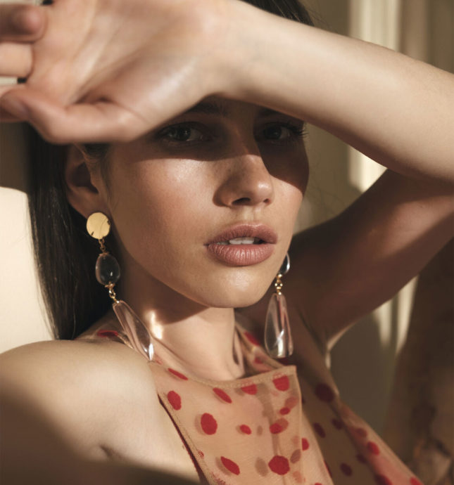 Girl wearing gold earring in sunlight