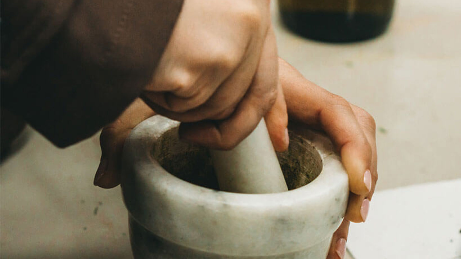 Hands working pestle and mortar